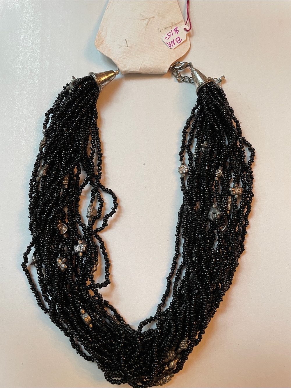 Necklace with multi strands of black beads and silver charms